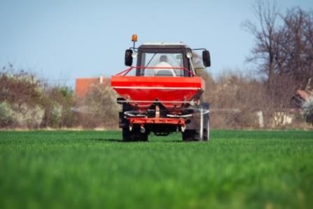 Tractor fertilizing in wheat field